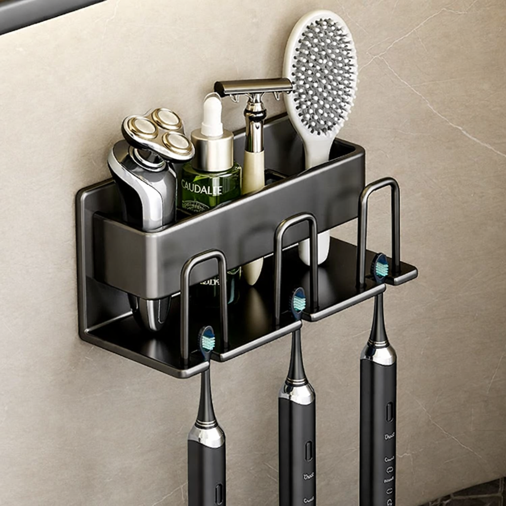 Bathroom shelf with toiletries including a razor, bottles, and toothbrushes on a beige tiled wall.