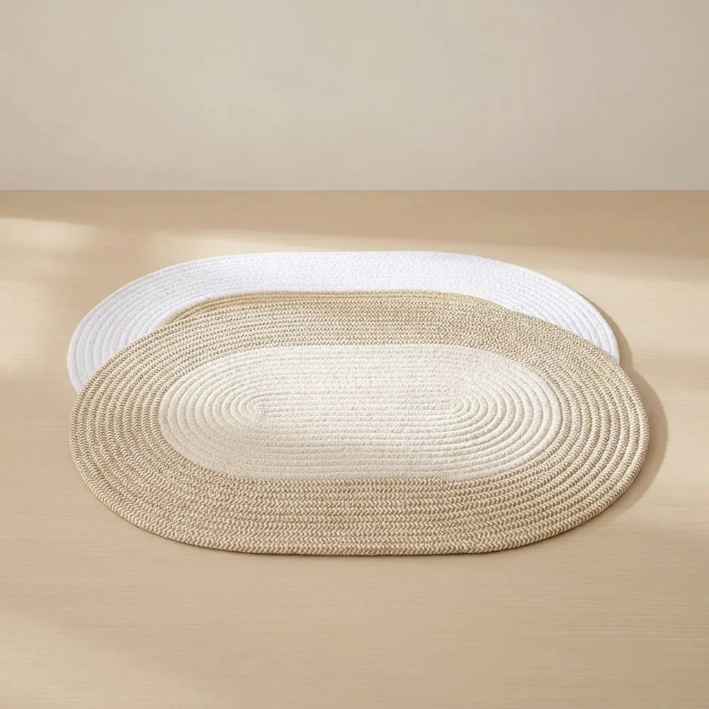 Round braided rug in beige and white on a beige floor.