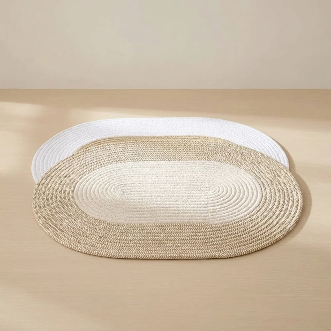 Round braided rug in beige and white on a beige floor.