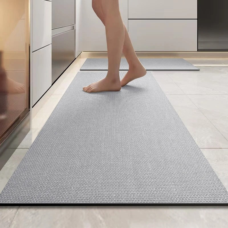 Person walking on a textured gray rug in a modern kitchen.