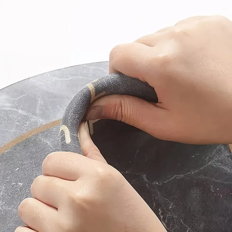Close-up of hands using a tool on a marble surface