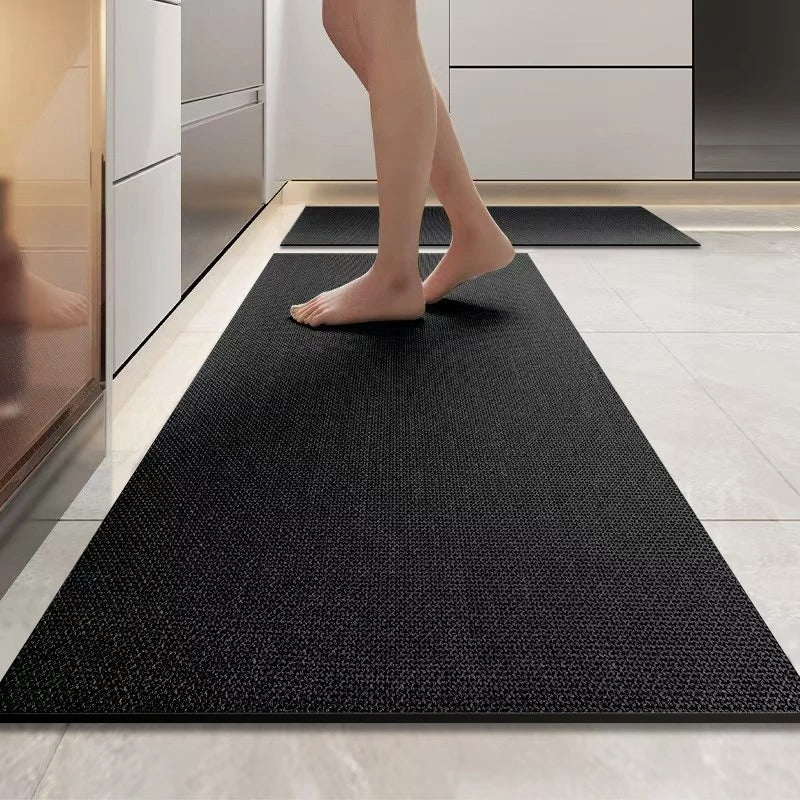 Person stepping onto a black mat in a modern kitchen setting