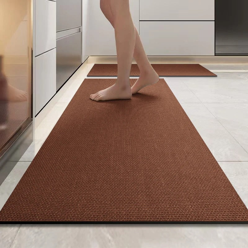 Brown rug on a kitchen floor with a person stepping onto it